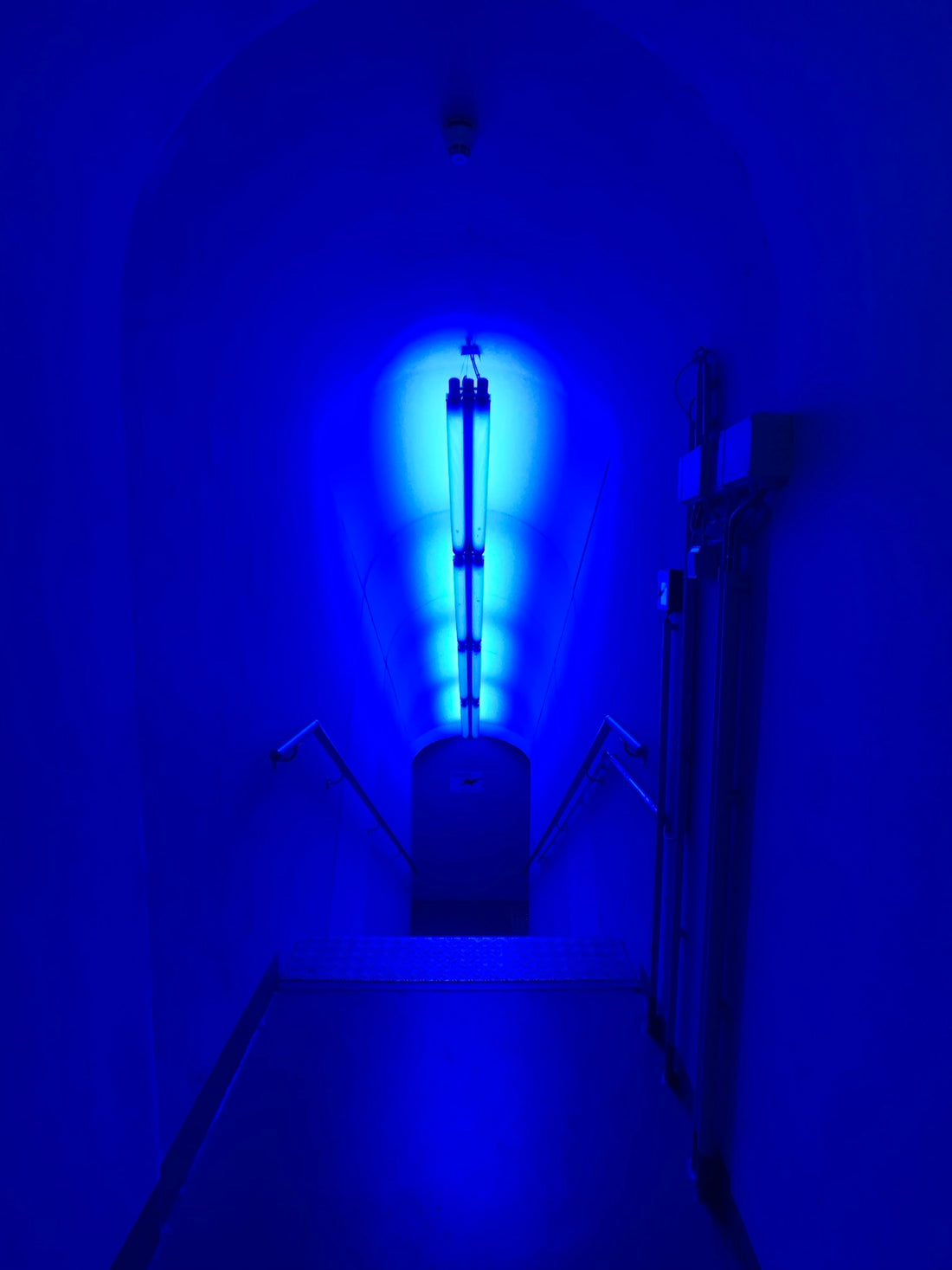 a dark hallway with a blue light in the corner